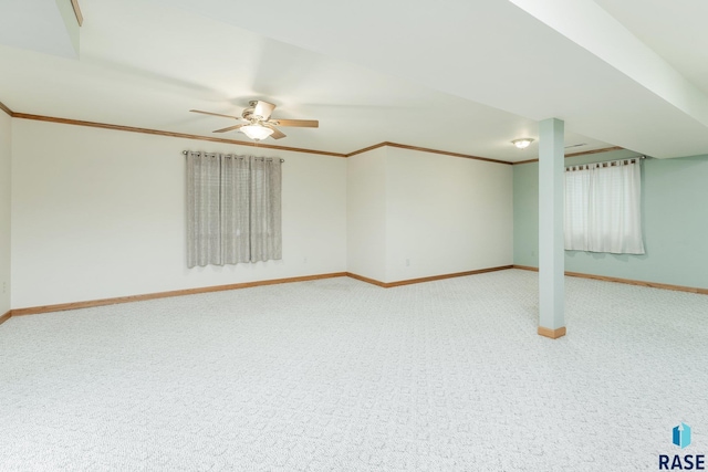 basement featuring ceiling fan, ornamental molding, and carpet