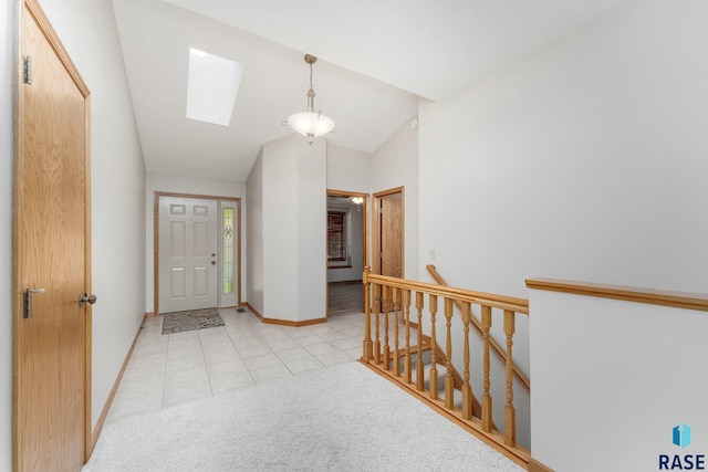 entrance foyer with lofted ceiling with skylight and light tile patterned floors