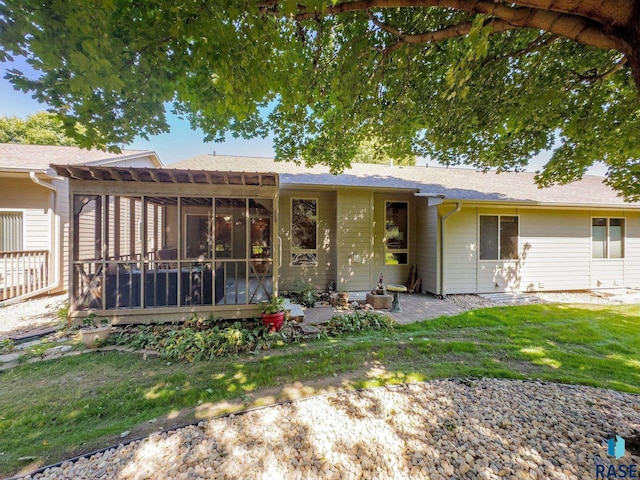 ranch-style home with a sunroom and a front lawn