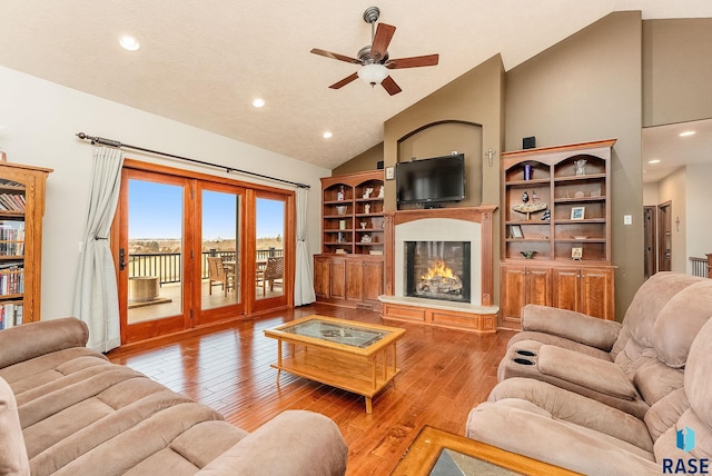 living room with ceiling fan, high vaulted ceiling, and light wood-type flooring