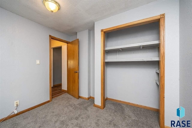 unfurnished bedroom featuring a closet, a textured ceiling, and carpet