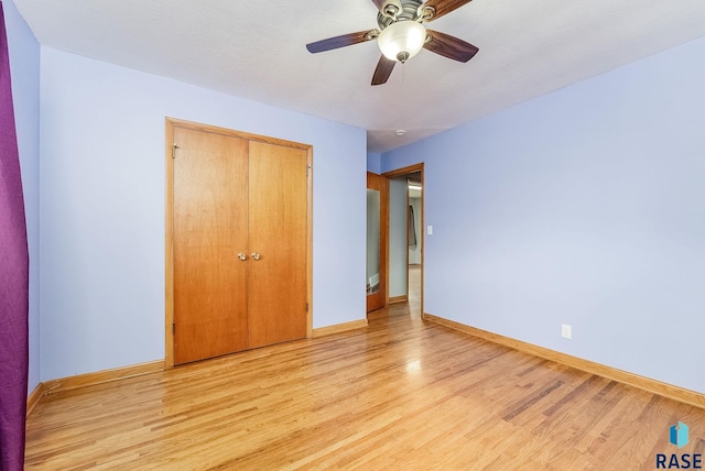 unfurnished bedroom featuring ceiling fan, light hardwood / wood-style floors, and a closet