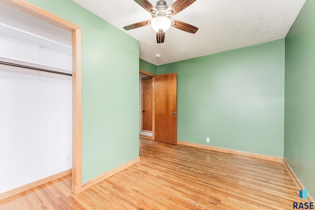 unfurnished bedroom featuring light hardwood / wood-style floors, ceiling fan, and a closet