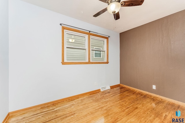 empty room featuring ceiling fan and light hardwood / wood-style floors