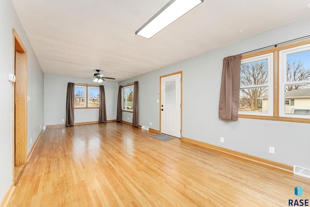 unfurnished room with ceiling fan, plenty of natural light, and light wood-type flooring