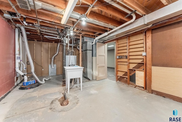 basement featuring water heater and sink