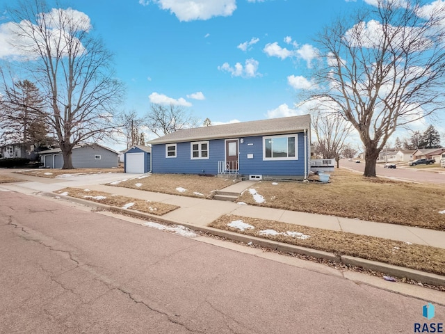 view of front of home featuring an outbuilding, a garage, and a front yard