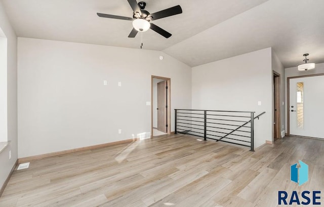 empty room featuring vaulted ceiling and light wood-type flooring