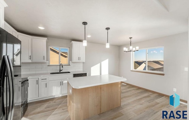 kitchen featuring backsplash, sink, a kitchen island, and white cabinets