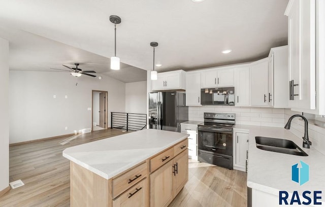 kitchen with sink, white cabinetry, tasteful backsplash, black appliances, and a kitchen island