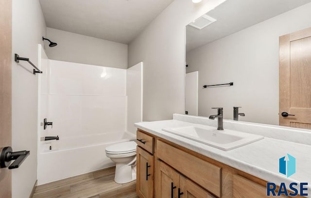 full bathroom featuring bathtub / shower combination, vanity, toilet, and hardwood / wood-style flooring