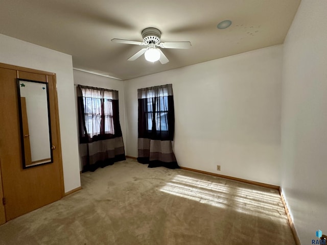 spare room with light carpet and ceiling fan