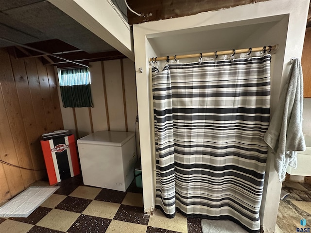 bathroom featuring wood walls