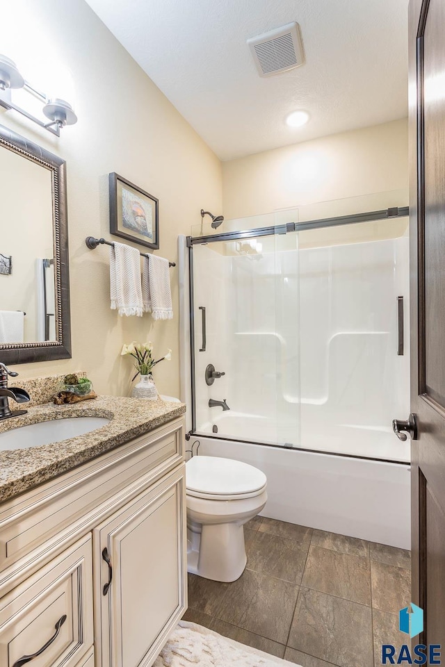 full bathroom with enclosed tub / shower combo, vanity, and toilet