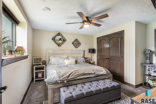 carpeted bedroom featuring ceiling fan and a textured ceiling