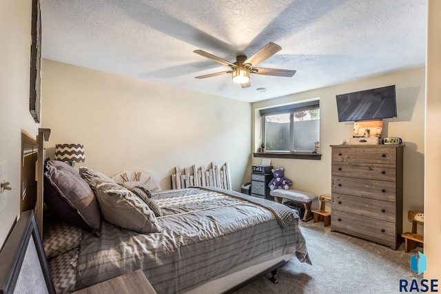 carpeted bedroom featuring a textured ceiling and ceiling fan