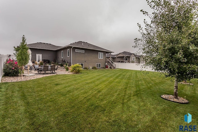 back of property with a yard and a patio