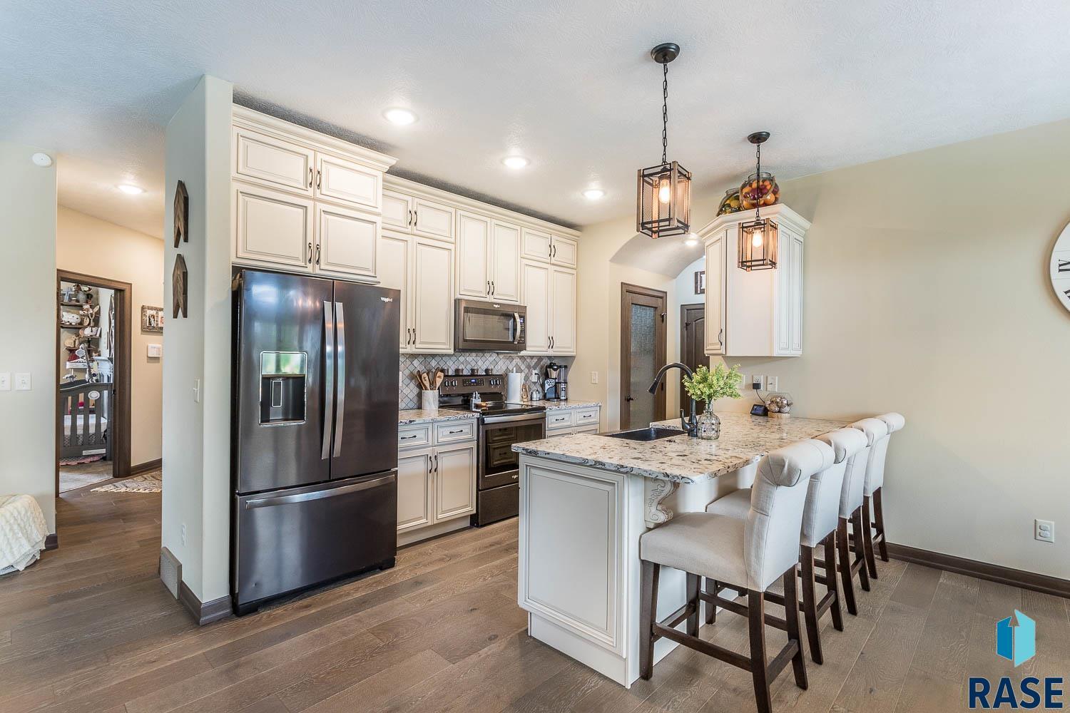 kitchen featuring sink, dark hardwood / wood-style flooring, pendant lighting, stainless steel appliances, and backsplash