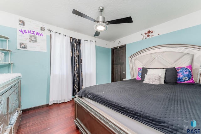 bedroom with dark hardwood / wood-style floors, a textured ceiling, and ceiling fan