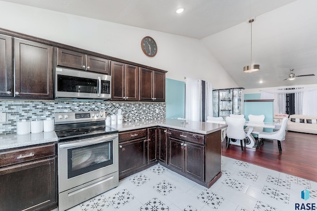 kitchen with vaulted ceiling, pendant lighting, decorative backsplash, kitchen peninsula, and stainless steel appliances