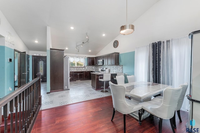 dining space featuring dark hardwood / wood-style floors and high vaulted ceiling