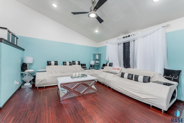 living room with ceiling fan, dark hardwood / wood-style flooring, vaulted ceiling, and a textured ceiling