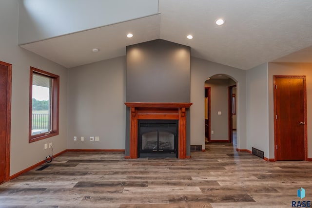 unfurnished living room featuring lofted ceiling and hardwood / wood-style floors