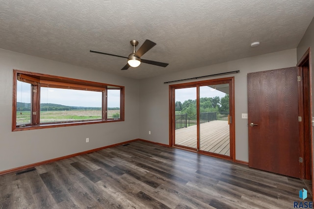 spare room with ceiling fan, dark hardwood / wood-style floors, and a textured ceiling