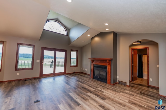 unfurnished living room featuring hardwood / wood-style flooring and vaulted ceiling