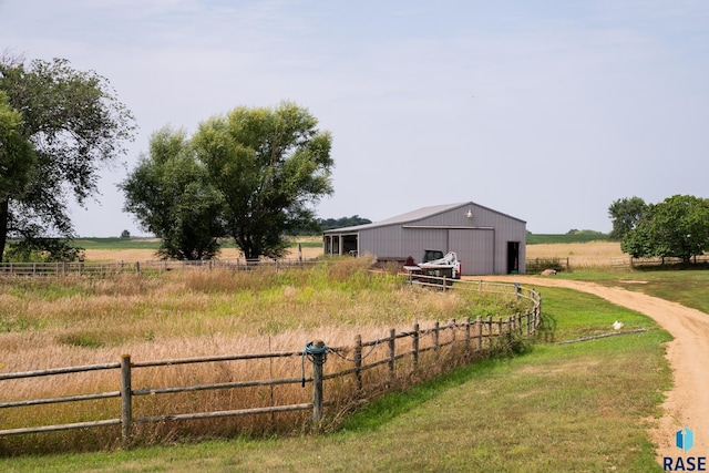 view of yard with an outdoor structure and a rural view