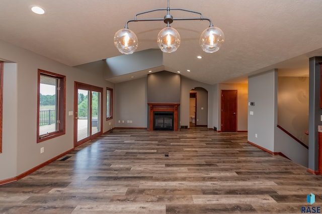 unfurnished living room with vaulted ceiling and dark hardwood / wood-style floors