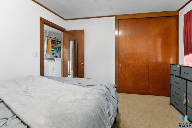 carpeted bedroom featuring washer / clothes dryer, crown molding, and a closet