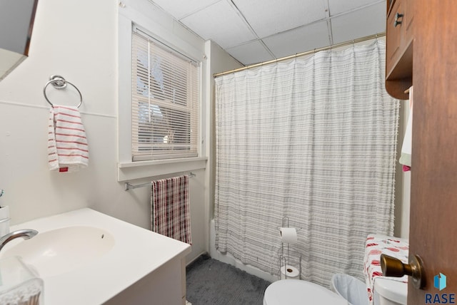 bathroom with a drop ceiling, vanity, and toilet