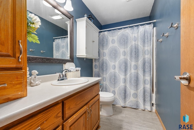 bathroom featuring vanity, hardwood / wood-style floors, curtained shower, and toilet