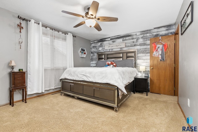 bedroom with light colored carpet, ceiling fan, and wood walls