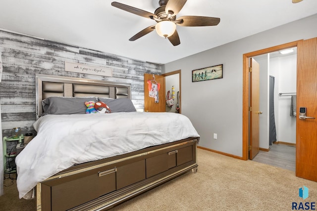 bedroom with light carpet, ceiling fan, and wood walls