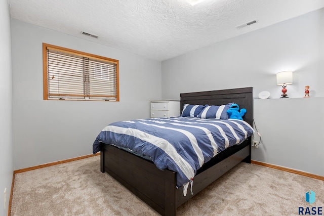 bedroom with light carpet and a textured ceiling