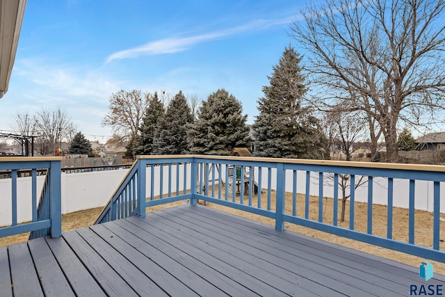 wooden terrace with a playground and a yard