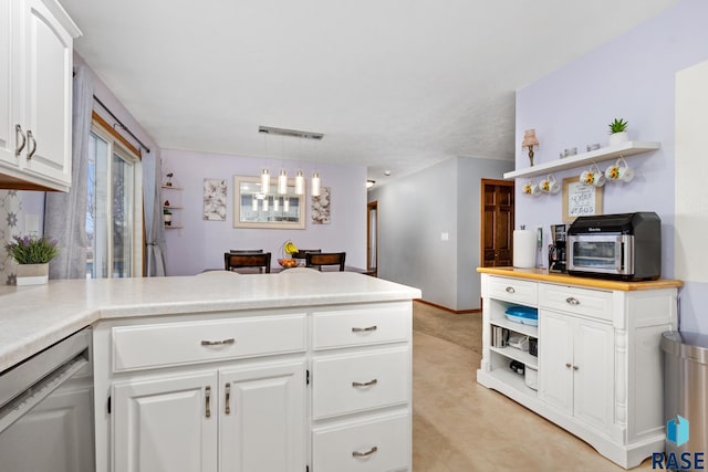 kitchen featuring white cabinetry, dishwasher, kitchen peninsula, and hanging light fixtures