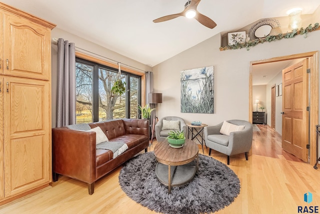 living room featuring ceiling fan, vaulted ceiling, and light wood-type flooring