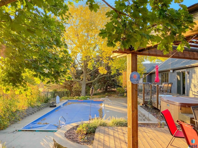 view of swimming pool featuring a hot tub and a deck