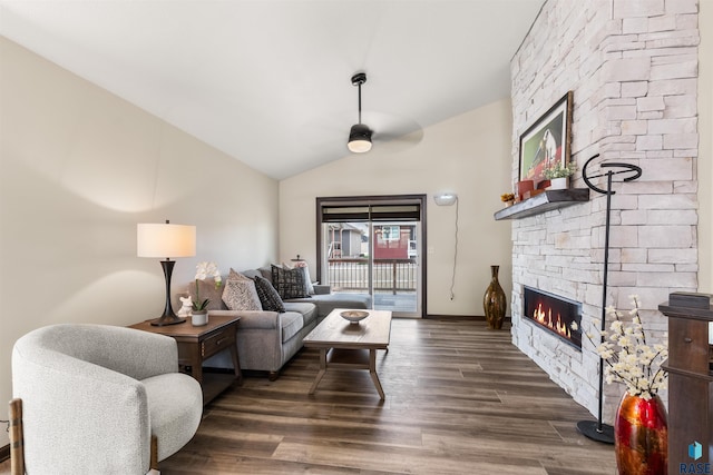 living room featuring lofted ceiling, a stone fireplace, dark hardwood / wood-style floors, and ceiling fan