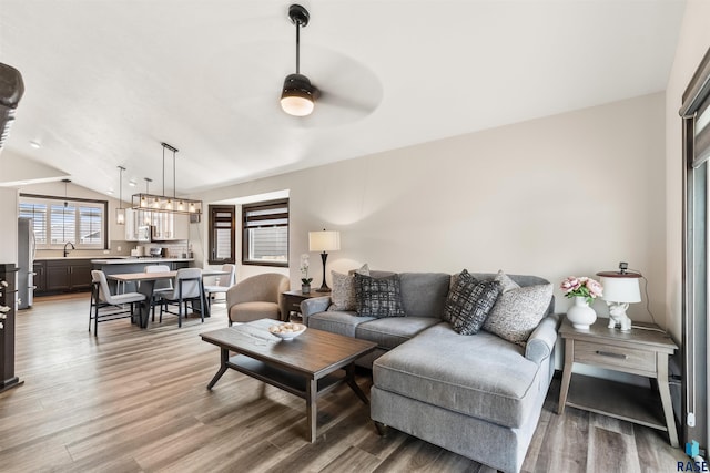 living room featuring vaulted ceiling, sink, hardwood / wood-style floors, and ceiling fan