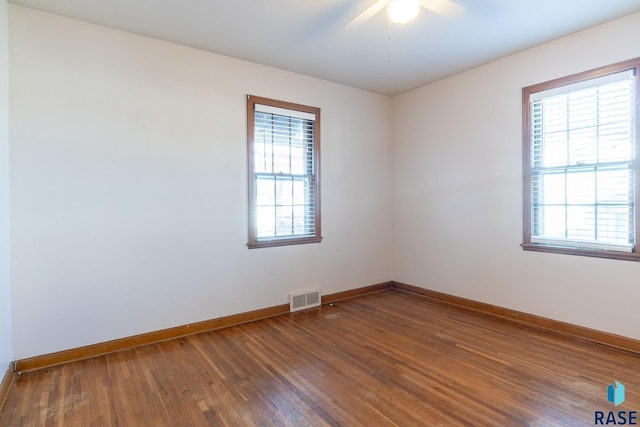 empty room featuring dark wood-type flooring and plenty of natural light