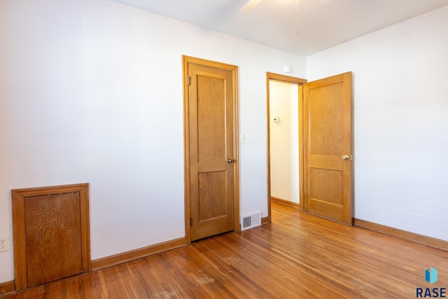 unfurnished bedroom with ceiling fan and wood-type flooring