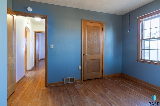 empty room with hardwood / wood-style flooring