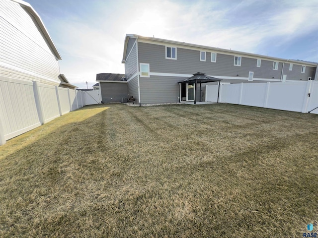 rear view of house with a gazebo and a lawn