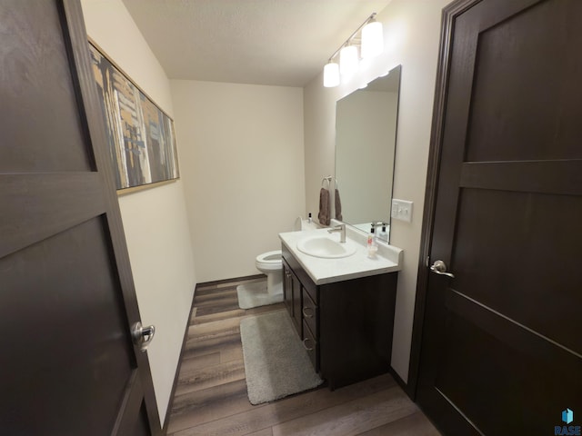 bathroom with vanity, hardwood / wood-style floors, and toilet