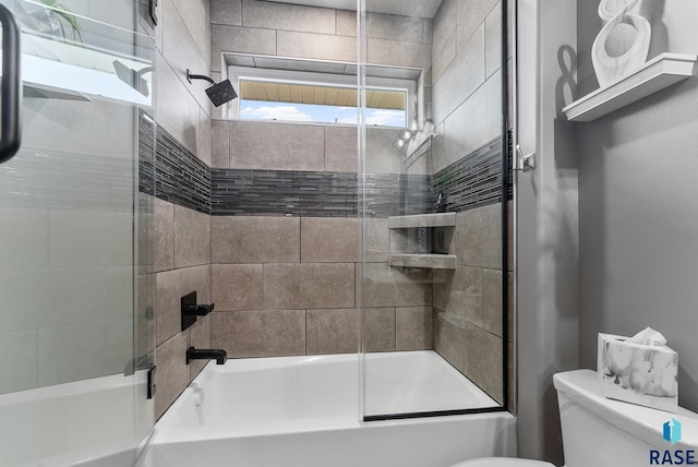 bathroom featuring shower / bath combination with glass door and toilet