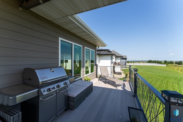 wooden terrace featuring a grill and a lawn